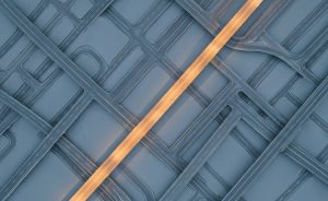 Overhead aerial photograph of a single illuminated path cutting clearly through a complex, grey labyrinth of intersecting roads, the path glowing in warm amber light against muted blue-grey tones, clean minimalist corporate photography style, no people, no text, wide 16:9 format, professional business metaphor for structured decision-making in change management, high detail, editorial quality